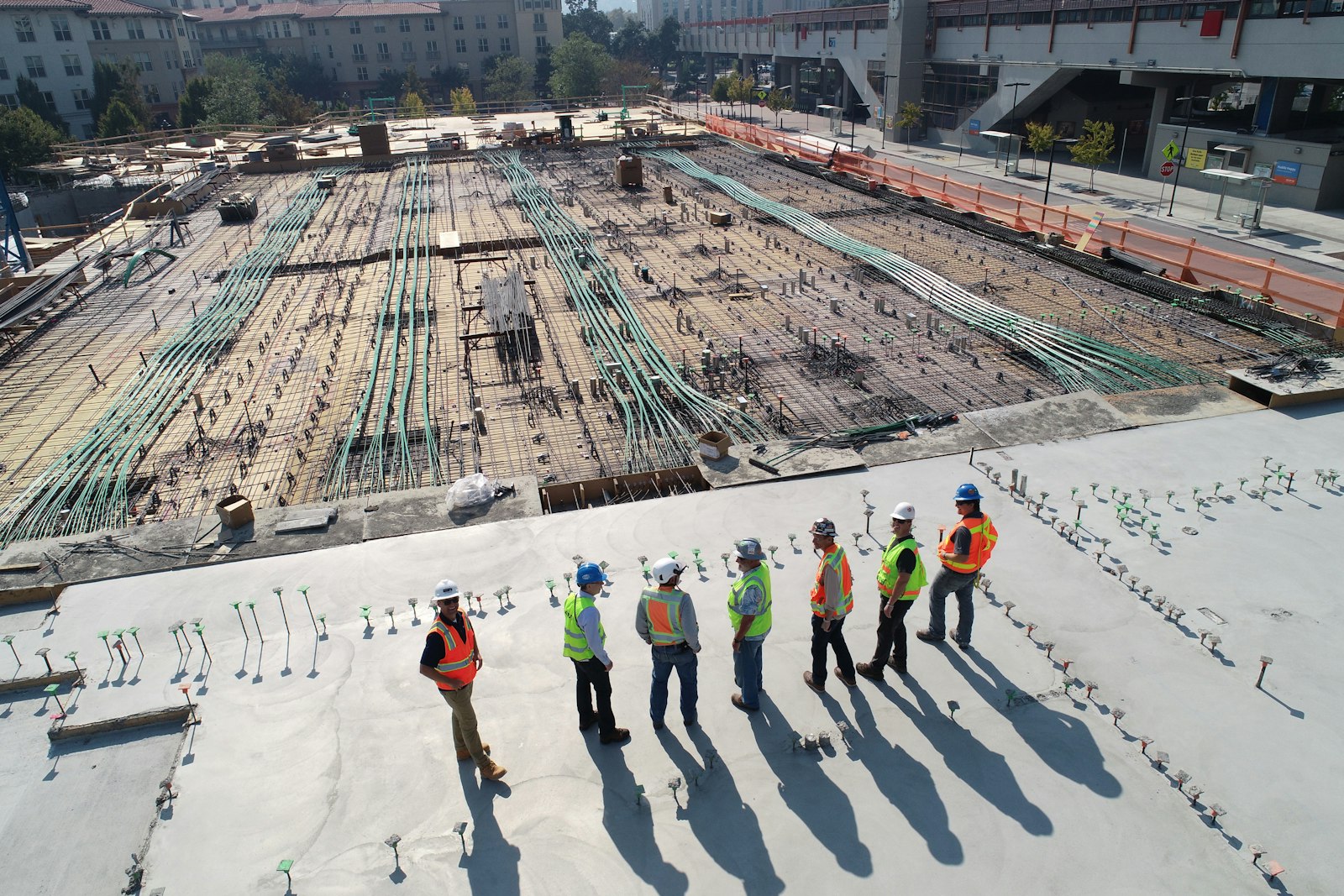 Aerial view of an infrastructure construction site with engineers reviewing the site